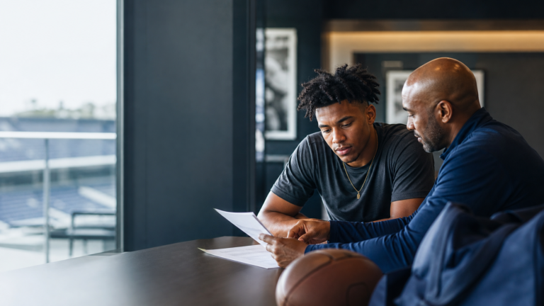 College athlete reviewing a name, image, and likeness agreement with a mentor