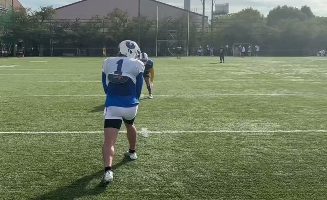 Boogie Knight, wearing No. 1, lined up against a defensive back at a Challengers practice field in Japan
