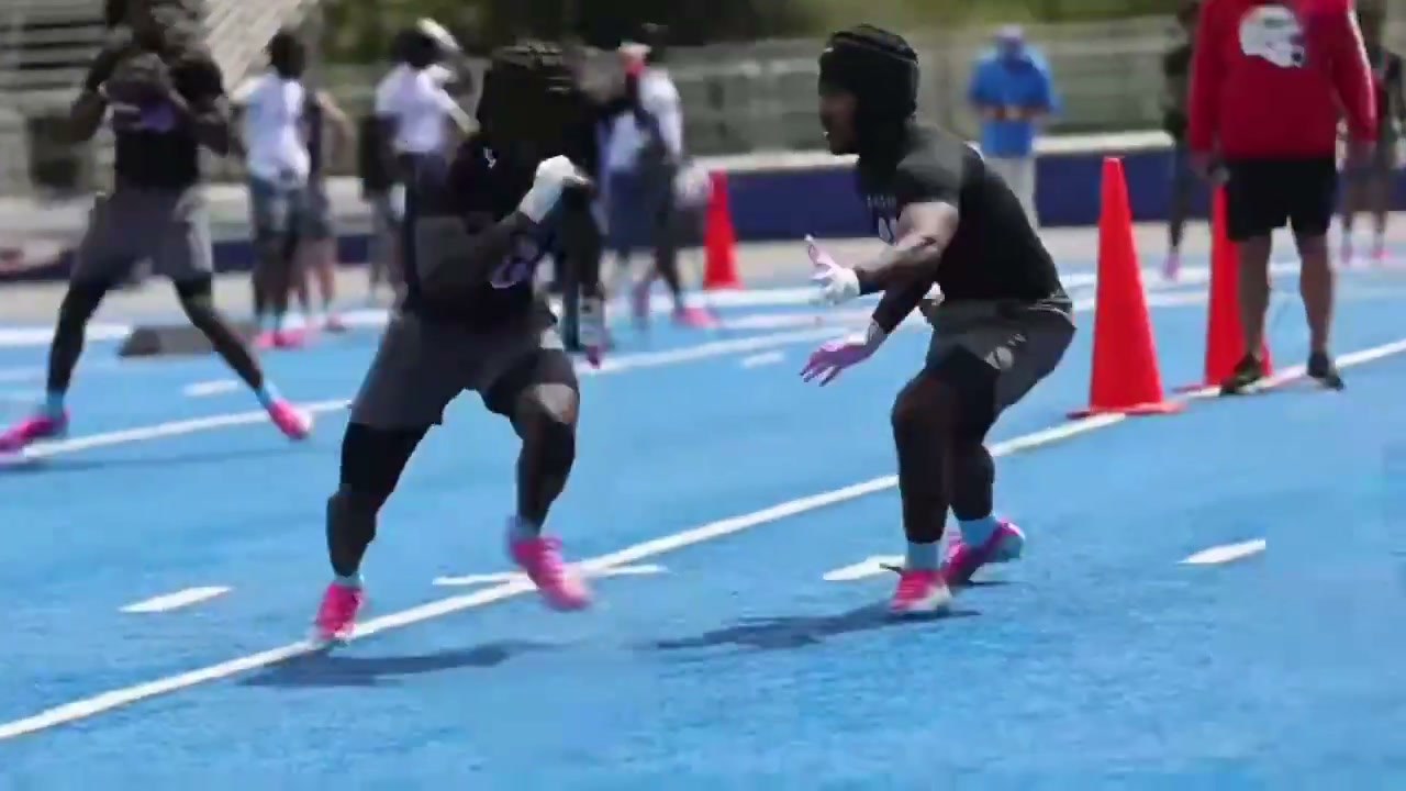 Dorian Franklin in a black helmet covering a receiver during a one-on-one rep at a football camp